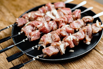 Pieces of raw meat are strung on skewers. Close-up. View from above.
