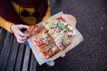 Top view of woman hand taking pizza