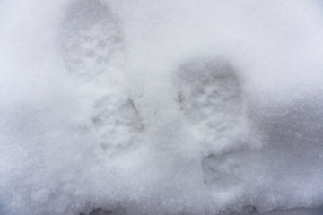 Footprints in fresh snow. Winter background. Human trace
