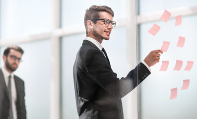 Fototapeta premium employee reads sticky-notes on glass.