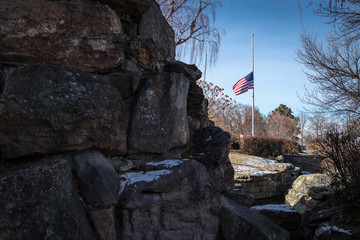 American flag at half mast is seen at a public park in the winter.