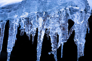 Transparent icicles on a black background.