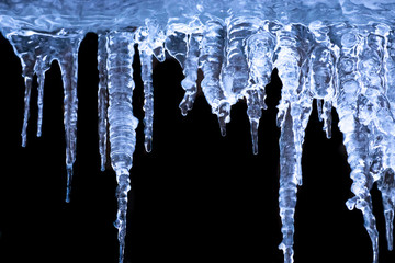 Transparent icicles on a black background. - obrazy, fototapety, plakaty