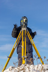 Surveyor conducts a topographical survey in winter for cadastral work at a construction site
