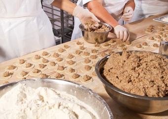female hands cook manually dumplings with meat