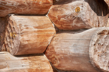 A fragment of the corner of a wooden building from logs. Background