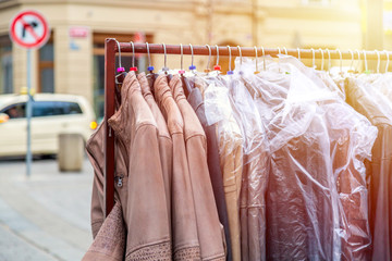 Leather jackets on rack for sale in outdoor market. European city.