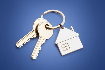 House keys with house shaped keychain,  on blue background