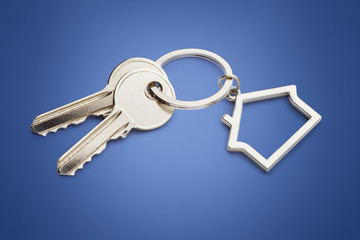 House keys with house shaped keychain,  on blue background