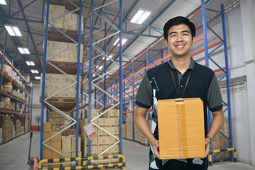 Worker carrying box in the warehouse (ฺBlur background) , Asian delivery man carrying boxes in the distribution warehouse (ฺBlur background)