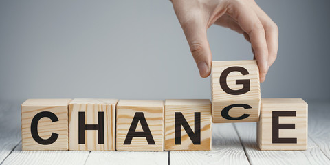 Hand flipping a wooden cube to remove the word 