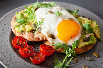 breakfast avocado sandwich with fried egg and tomato