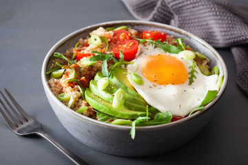quinoa bowl with fried egg, avocado, tomato, rocket. Healthy vegetarian lunch