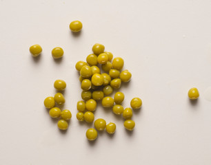 small pile of peas scattered on table, with shadow
