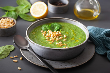 green creamy cauliflower spinach soup on gray background