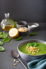 green creamy cauliflower spinach soup on gray background