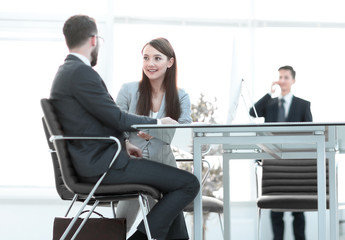 business colleagues talking, sitting behind a Desk