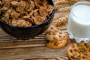 A healthy breakfast. Cereals are at the black plate on the wood background