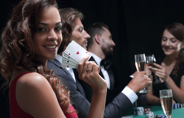 Woman at roulette table holding champagne glass in casino