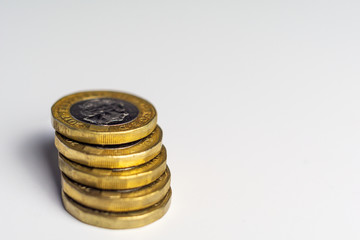 New British one pound sterling coins up close macro studio shot against white background.