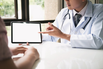 Doctor using computer tablet discussion something with patient.