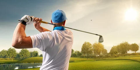 Poster Male golf player on professional golf course. Golfer with golf club taking a shot © Alex