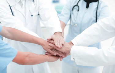doctors holding hands together at hospital