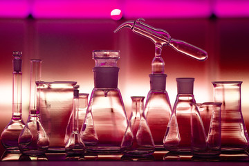 Empty chemical glassware on color background. Group of laboratory empty flasks   on color...