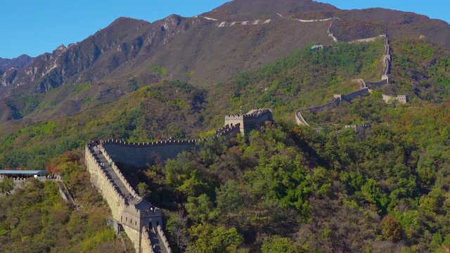 a section of the Chinese Great wall that rises up the side of the mountain in a begining of fall