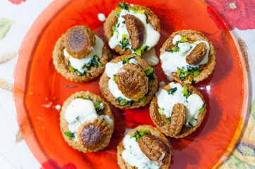 above view of red dish full of traditional french vol au vent made of puff pastry, whipped cream and leek, on flower decorated cloth