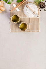 Asian food background, tea and chopsticks on a grey concrete background.