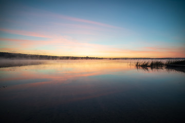 colorful misty sunset on the river in summer