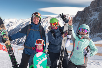 Happy family skiing at the mountains. Kids in ski school.