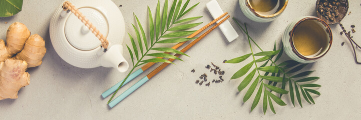 Asian food background, tea and chopsticks on a grey concrete background.