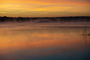 colorful misty sunset on the river in summer