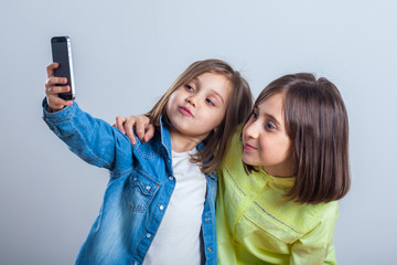 two sisters posing and taking selfies in the studio