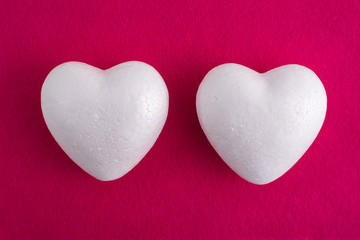 White foam heart on a red felt background