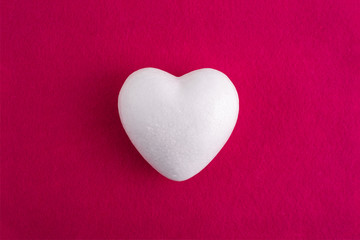 White foam heart on a red felt background