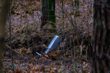 illegal dumpster in wet damp forest in autumn