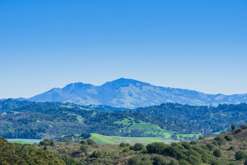 Fototapeta na wymiar Hills and meadows in Wildcat Canyon Regional Park; San Pablo Reservoir; Mount Diablo in the background, east San Francisco bay, Contra Costa county, California