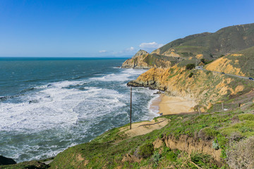 Aerial view of the rocky Pacific Ocean shoreline and scenic highway near Devil's Slide, California