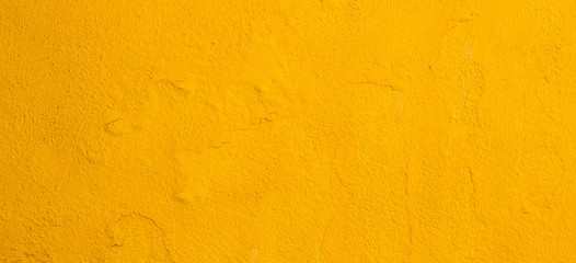 Old cracked yellow painted wall background