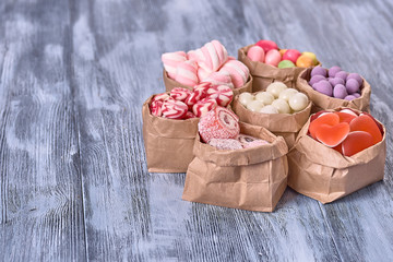 candy in a paper bag on a wooden background