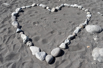 Heart shape from stones in black sand