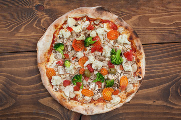 Fresh italian vegetariana pizza on wooden background, top view