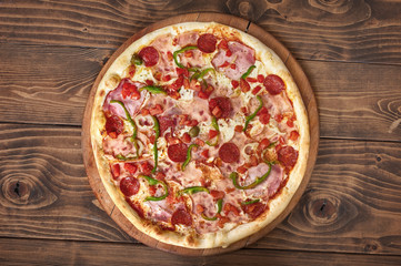 Pizza pepperoni with tomatoes, bacon and olives, side view