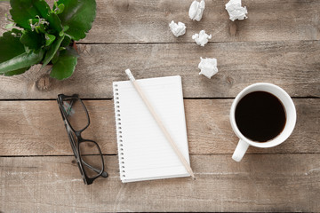 Notebook with drinking coffee on wooden table