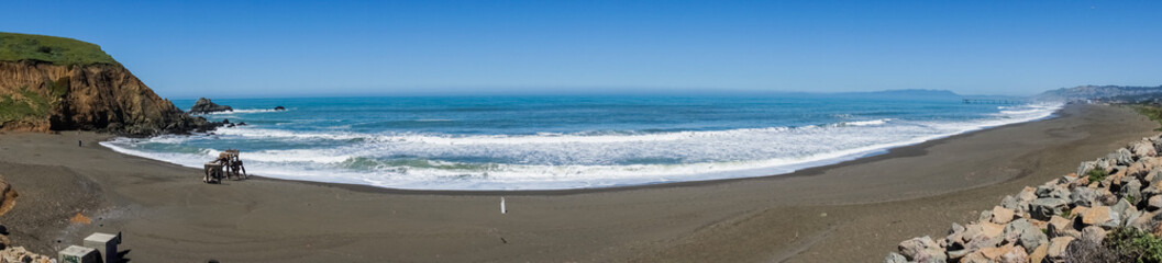 Panorama of large black sand beach, Pacific Ocean coastline, Mori Point, Pacifica, California