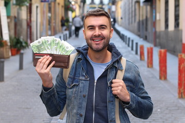 Successful young guy with full wallet outdoors