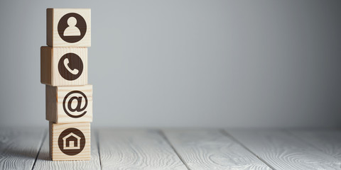 Symbols of contacts (name, phone, email and address) on wooden cubes on neutral background